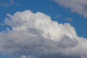 Fluffy white clouds formation on the blue sky.