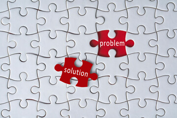 Business concept. Jigsaw puzzle with text problem and solution on red background