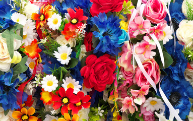 Bright wreaths of artificial flowers.