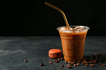 Plastic cup of iced coffee on dark background
