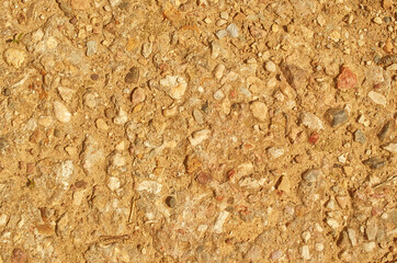 The texture of a dirt road with small stones and sand.