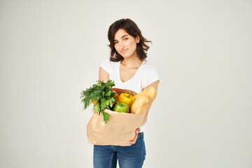 woman with package of healthy food supermarkets delivery light background