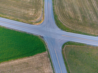 Aerial shot of a crossroad between grassland and fields