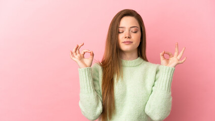 Teenager girl over isolated pink background in zen pose