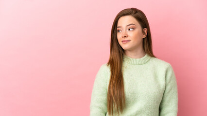 Teenager girl over isolated pink background making doubts gesture looking side