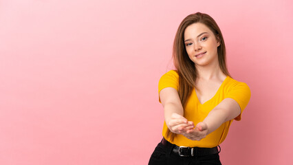 Teenager girl over isolated pink background holding copyspace imaginary on the palm to insert an ad