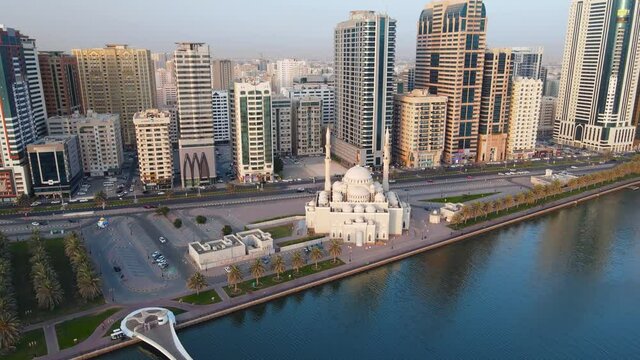 Sharjah aerial view above Al Noor island and mosque and downtown rising above Khalid lake