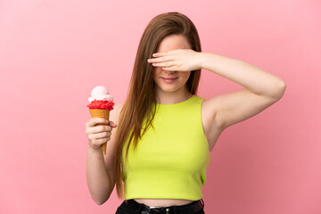 Teenager girl with a cornet ice cream over isolated pink background covering eyes by hands. Do not want to see something