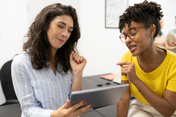 multiracial coworkers using tablet in coworking