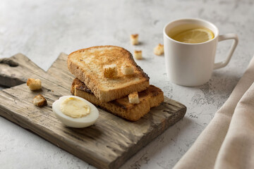 a cup of tea with lemon and eg with toast
