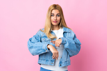Young Uruguayan blonde woman over isolated pink background making the gesture of being late