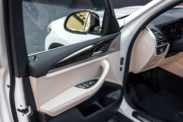 Driver's open car door close up. Control panel on driver's door. Selective focus.