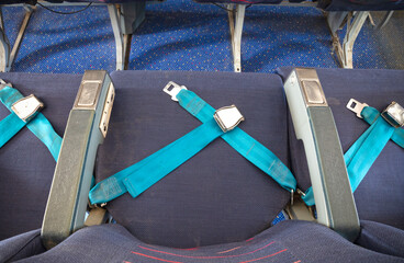Opened seat belt in an old airplane with empty seat - Security concept