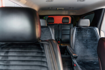 Two rows of passenger seats in a modern luxury car. Selective focus.