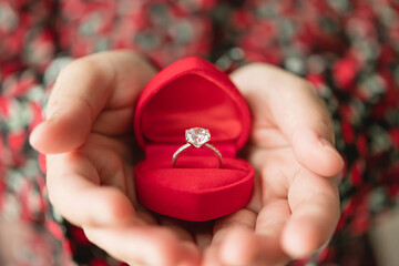 hands holding diamond ring in jewelry box