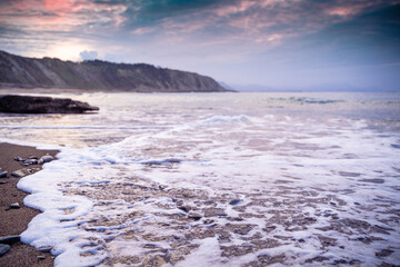 Fototapeta na wymiar rocky beach at sunset in a cloudy da