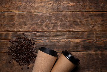 Two coffee mugs and roasted coffee beans on the wooden table flat lay background with copy space.