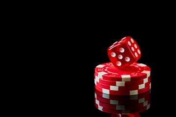 Red casino dice and chips isolated over black reflective background