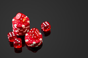 Red casino dice and chips isolated over black reflective background