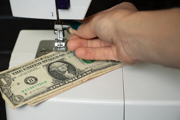 one dollar lies on a sewing machine, money production, finance, income and work
