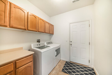 Laundry room with wooden wall cabinets and drawers