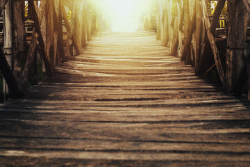 Old wooden bridge with sunlight shining through in the evening