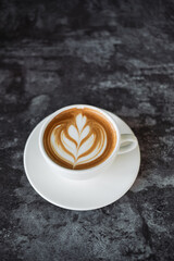 Latte art coffee on wooden table in coffee shop