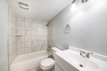 Exterior of a white bathroom with ceramic tiles surround and flooring