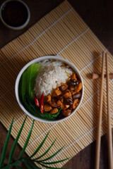 a bowl of rice with chicken meat and mushroom sauce 