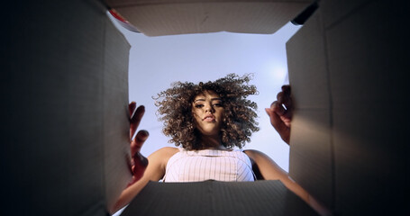 Beautiful sad brunette with curly hair opening the box with your order received by the post office...