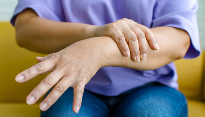 Woman using hand to hold other her palm with feeling pain, hurt and tingling. Concept of Guillain barre syndrome and numb hands disease.