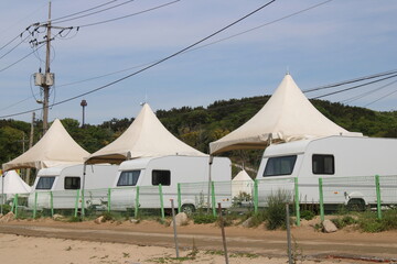 White campers and pavilion tents on beach