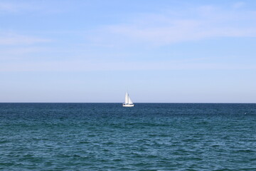 Fototapeta premium White sailboat cruising on the ocean