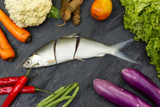 vegetables and sliced milkfish isolated on wooden background for copy space, photography background, etc.