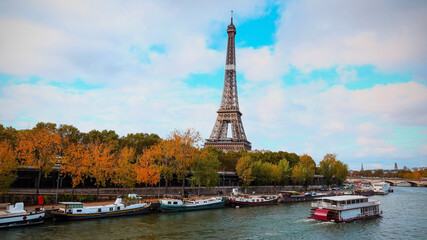 Fototapeta na wymiar Romantic view in Autumn season with Eiffel Tower and boats on Seine river in Paris, France.