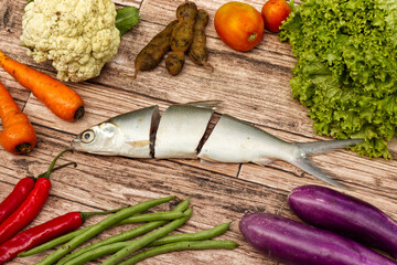 vegetables and sliced milkfish isolated on wooden background for copy space, photography...