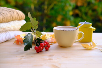 tea, coffee in a mug on the table in the garden, a candle is burning in a candlestick, the concept of outdoor tea drinking, good weather, a cozy autumn mood