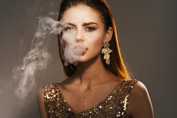 woman golden dress smoke from the mouth decoration luxury