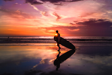 silhouette of a surfer in the sunset