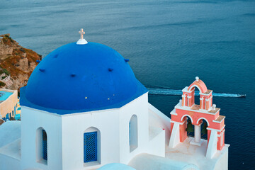 Famous view from viewpoint of Santorini Oia village with blue dome of greek orthodox Christian...