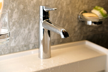 water pours a thin stream from a chrome plated faucet, bathroom interior, the concept of a healthy lifestyle, cleanliness, health, treatment, save water resources