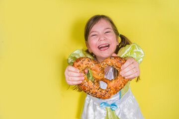 Oktoberfest holiday, kid girl with pretzel - obrazy, fototapety, plakaty