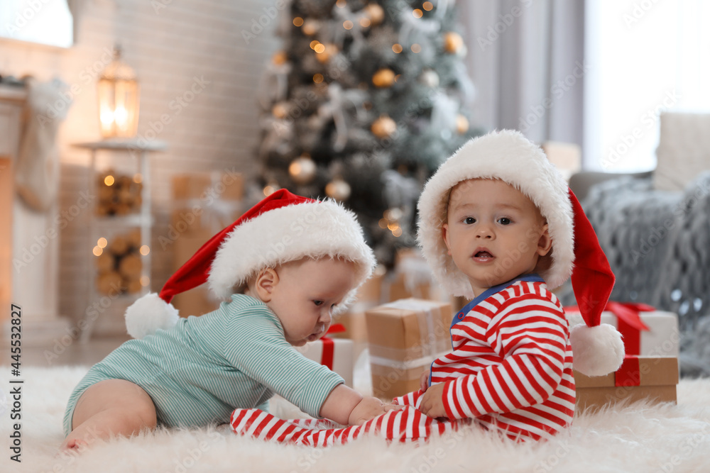 Sticker cute children in santa hats on floor in room with christmas tree