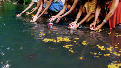  Hands of girls let flowers in the water - obrazy, fototapety, plakaty