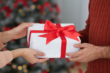 Couple with Christmas gift at home, closeup