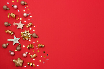 Festive Christmas Background or Card Red and Gold Holiday Decorations and Confetti and C on Red Background Top View Horizontal Copy Space