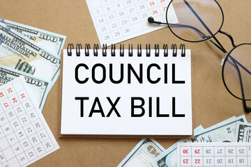 COUNCIL TAX BILL. text on white notepad paper near calendar on wood craft background