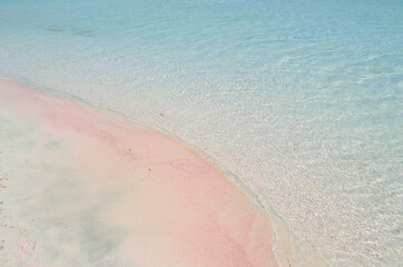 Fototapeta na wymiar Pink paradise sandy beach with blue water.