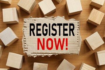 Register Now, text on torn cardboard on wood cubes background