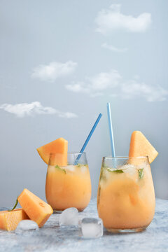 Fresh melon juice on the table with cloudy sky background, preparing melon  juice by raw ripe biological fruit, food background
